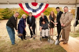 Coolbaugh Supervisor Jim Frutchey, Commissioner Suzanne McCool, PMEDC’s Chuck Leonard, Patrick Kelley and his daughter Elizabeth Kelly of Waste Not Technologies, LLC, Kristine Dolan, Brian Fenstermaker, and Michael Kushner holding shovels under a tent in a field