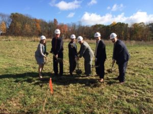 State Rep. Rosemary Brown, Smithfield Township Supervisor Stephen Carey, State Senator Dave Argall, State Rep. Mario Scavello, Lawry Simon and PMEDC Chair Michael Baxter all wearing hard hats and carrying shovels in a large field