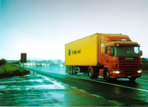 Photo of a large yellow box truck driving on the highway
