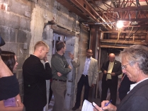 Individuals are taking notes and discussing ideas in a stone building that appears under renovation