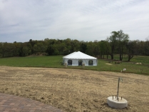 A white tent is set up in a field