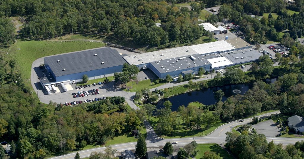 Aerial photo of industrial buildings with parking and near highway
