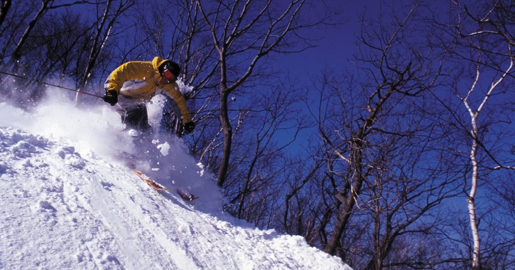Person in ski equipment coming down a snowy hillside